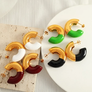 Minimalist C-shaped hoop earrings in gold with colorful enamel finish on a stone display