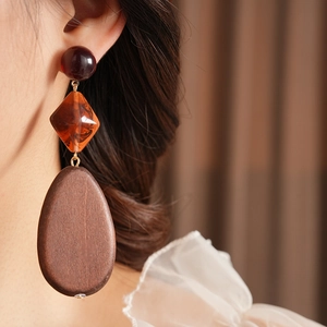 Detail of vintage earrings with wood teardrops, resin beads and amber diamonds
