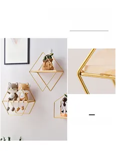 Detail of Nordic hexagonal gold metal wall shelf with solid wood base and decor