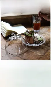 Detailed close-up of a glass cloche with a beaded edge tray for cakes and desserts