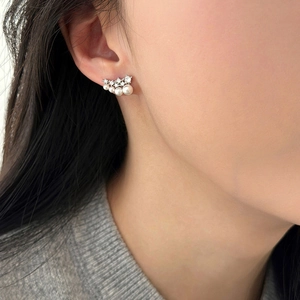 Elegant silver pearl and zircon earrings worn by a model in a natural lifestyle setting