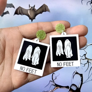 Macro detail of Halloween ghost acrylic earrings featuring Polaroid design with No Feet text