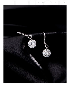Vue macro de boucles d'oreilles en argent avec moissanite brillante sur cuir