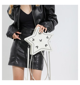 Close-up of white star-shaped crossbody bag with stud rivets and black butterfly pattern