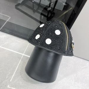 Detail of mushroom shaped crossbody bag featuring black rhinestones and white dots