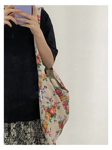 Floral canvas shoulder bag with colorful flower patterns shown on a model in a mirror selfie
