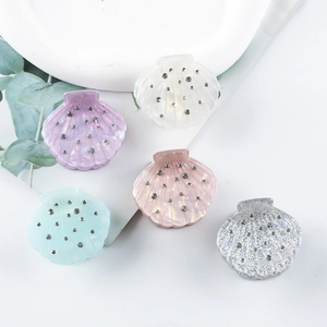 Cinq pinces à cheveux en acrylique en forme de coquillage aux couleurs pastel avec strass