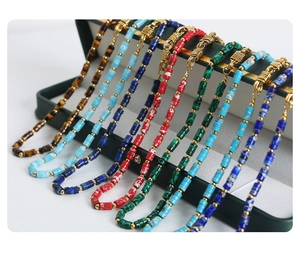 Detailed shot of assorted gemstone necklaces with gold metal beads in a jewelry display tray