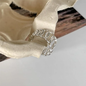 Macro detail of geometric hollow oval link ring in 925 sterling silver minimalist style