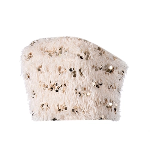 Dettaglio del top a fascia beige con piume sintetiche di lusso e decorazioni di paillettes
