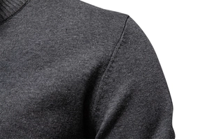 Détail d'un pull en coton ajusté montrant la texture de la maille fine grise sur l'épaule