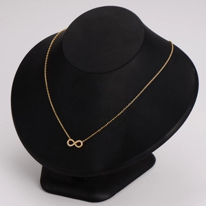 Collier élégant symbole infini doré avec cristaux pavés sur un buste à bijoux
