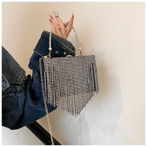 Detail of silver rhinestone clutch with V-shaped tassels and elegant pearl handle detail