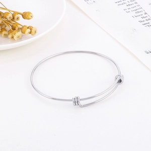 Minimalist adjustable silver stainless steel wire bangle on clean white background