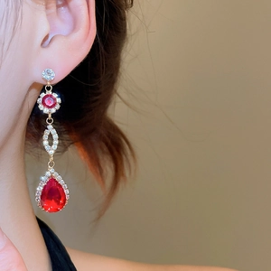 Detailed close-up of a long drop earring featuring pear-shaped red rubies and zircons