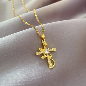 Detail of gold cross necklace with rose floral design and sparkling cubic zirconia inlay