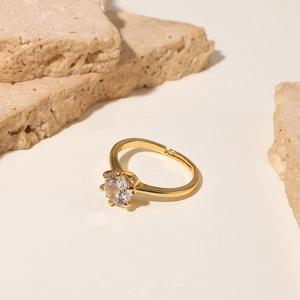 Classic 18K gold plated ring with round cubic zirconia on elegant stone background