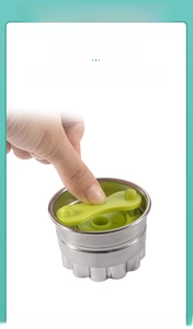 Close-up of stainless steel cookie cutter with ergonomic green press handle mechanism