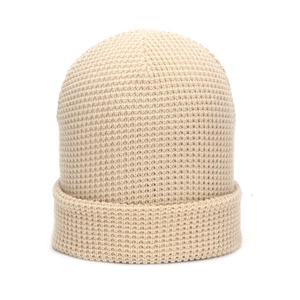 Detailed waffle knit texture of a warm beige beanie for autumn and winter season