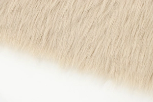 Close-up of soft warm white faux fur texture on long coat with high-quality fibers