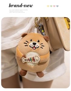Cute brown otter plush keychain with embroidered fish bone on a beige leather bag