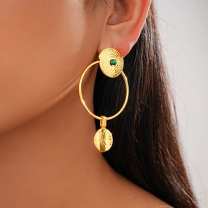 Detailed close-up of 24K gold plated textured disc earrings with green gemstones