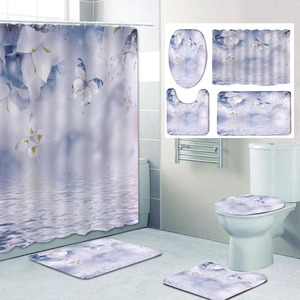 Detail of four-piece bathroom set with purple floral shower curtain and matching non-slip mats