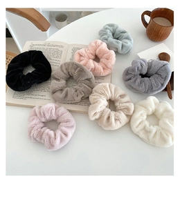 Set of eight plush faux rabbit fur hair scrunchies in assorted soft colors on a white table