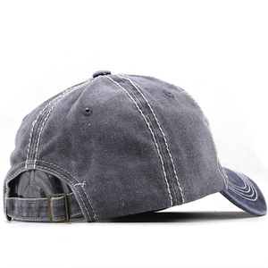 Detail of dark gray washed baseball cap with white stitching and metal buckle strap