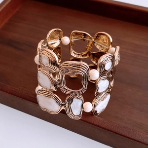 Detailed view of vintage gold hollow cuff bracelet with white marble resin and ripples