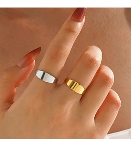 Polished gold and silver stainless steel signet rings worn for a minimalist fashion look