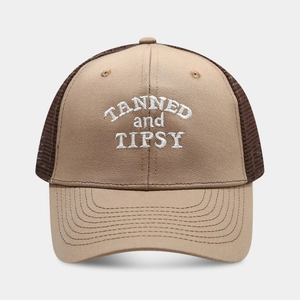 Close-up of Tanned and Tipsy embroidery on a breathable beige and brown trucker hat