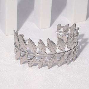 Close-up of silver laurel leaf open bangle in polished stainless steel on white texture