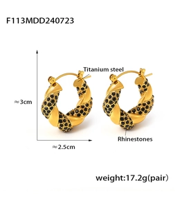 Macro shot of U-shaped gold titanium earrings with black rhinestones and twist design