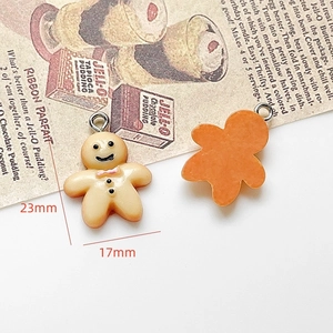 Macro detail of gingerbread man resin charms showing 23x17mm size for DIY jewelry