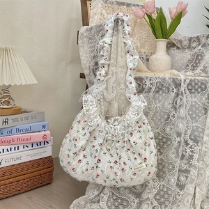 Détail d'un sac en dentelle florale avec volants superposés et imprimé rose délicat