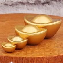 Set of four polished gold Chinese sycee ingots on a circular wooden tray display