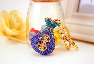 Detail of blue rhinestone money bag keychain with gold dollar sign and metal clasp