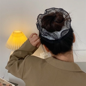 Chouchou élégant en dentelle noire aux plis vintage porté sur un chignon stylé