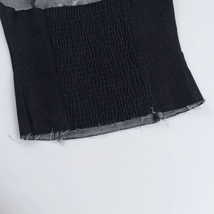Vue détaillée du denim bleu foncé avec plis froncés et bords effilochés naturels
