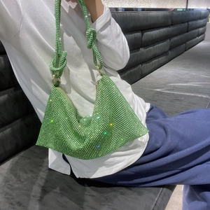 Detail of green rhinestone hobo bag with knotted shoulder strap worn by a model
