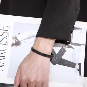 Detail of black woven leather and stainless steel mesh bracelet with magnetic clasp on model