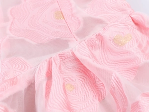 Gros plan du tissu jacquard rose avec motifs floraux et détails dorés brillants