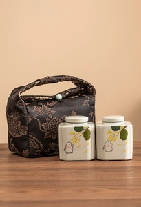 Close-up of ceramic tea canisters with hand-painted rabbits and floral patterns