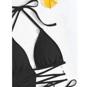 Detail of black halter bikini top with adjustable straps and textured ruffle trim