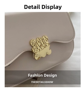 Detailed macro view of the gold bear-shaped geometric buckle and textured leather bag