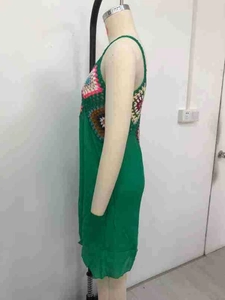Détail du patchwork au crochet coloré sur la robe de plage bohème verte en coton