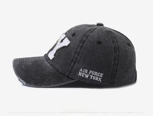Detail view of washed grey baseball cap with embroidery and distressed brim edge