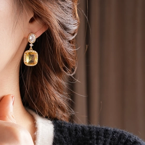 Detail view of 18K gold plated square yellow gemstone earring with clear accents