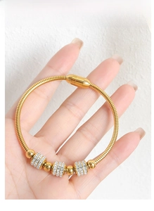Detail of gold snake chain bracelet featuring sparkling pavé crystal beads and magnetic clasp